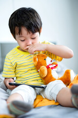 little kid boy using digital tablet or smart phones for playing games and watching cartoons, smart phone mobile addiction technology communication lifestyles.