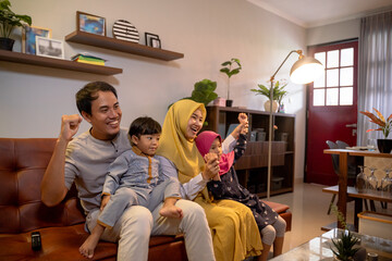 Asian muslim family having fun in livingroom