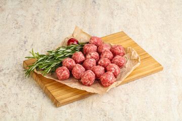 Raw uncooked beef meatballs served rosemary