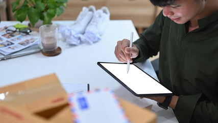 Small business owner using digital tablet receive order from customer.