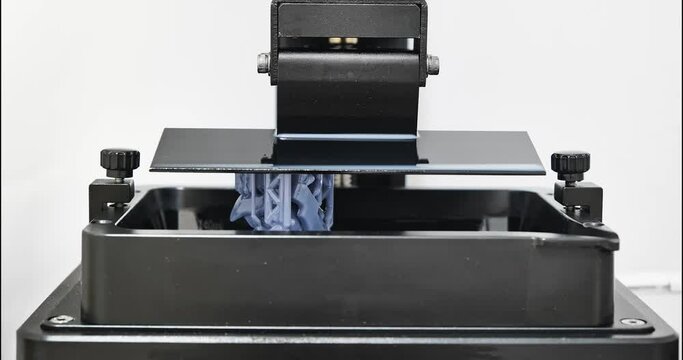Time lapse of SLA 3D printer printing part form liquid resin using MSLA or Masked Stereolithography. Front view Time lapse of resin MSLA 3d printer, additive manufacturing.