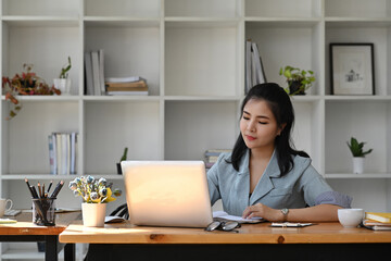 Fototapeta na wymiar Asian business woman using laptop computer at office desk.