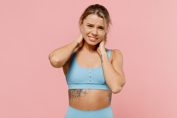 Fototapeta na wymiar Young unhappy sad strong sporty athletic fitness trainer instructor woman wearing blue tracksuit spend time in home gym hold hands behind neck isolated on plain pink background Workout sport concept.