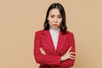 Sad displeased indignant shrewd woman of Asian ethnicity 20s wear red jacket look camera hold hands...