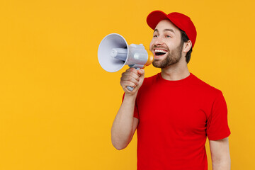 Delivery guy employee man wear red cap T-shirt uniform workwear work as dealer courier hold scream in megaphone announces discounts sale isolated on plain yellow background studio. Service concept