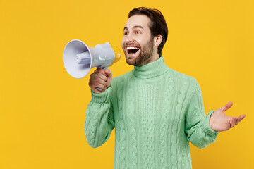 Young caucasian man 20s wearing mint knitted sweater hold scream in megaphone announces discounts...