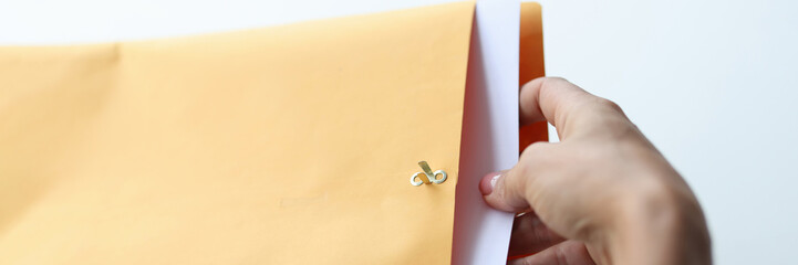 Woman hand takes out letter from envelope closeup