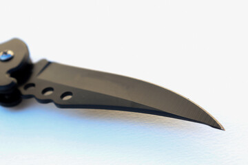 Isolated designer black knife point. Isolated knife with textured white background. knife on paper