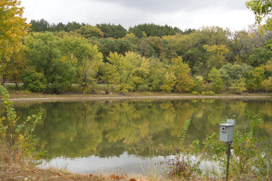 A landscape of Tuttle Creek Lake surrounded by greenery under a cloudy sky in Kansas, the US
