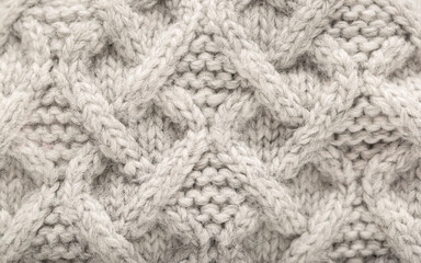 Knitted light surface of wool things as a background. Closeup of gray texture knitting patterns. Background with warm winter textile copy space.