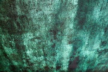 Abstract dark green background with scuffs and scratches.