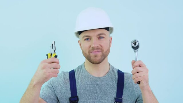 Handyman in overalls showing his tools