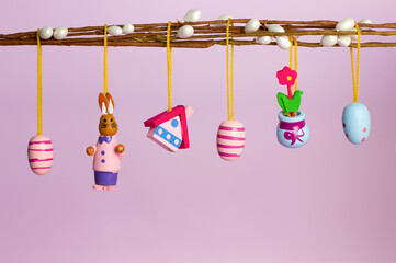Easter decorations on a willow branch on a pink background with copyspace