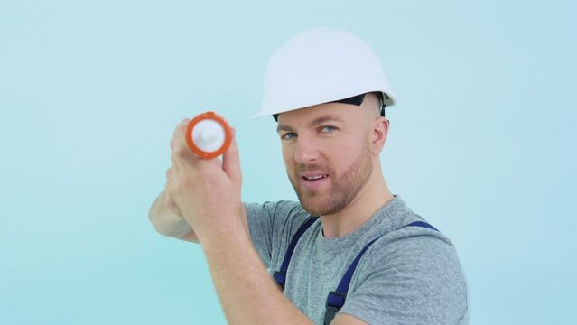 Repairman in overalls holding silicone adhesive