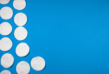 
cotton pads with a side arrangement on a blue background with a place for text.