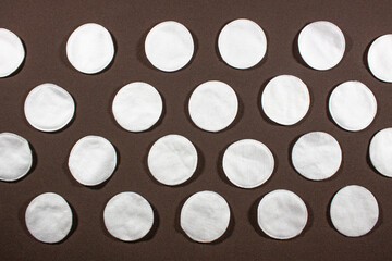 hygienic cotton pads on a brown background top view