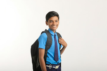 Indian school boy standing on white background.