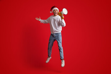 Happy Excited Man Wearing Santa Hat Jumping With Loudspeaker, Making Xmas Announcement