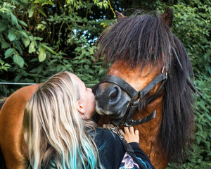 little caucasian white girl with her pony horse