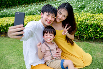 little boy taking photo with mom and dad, happy family.