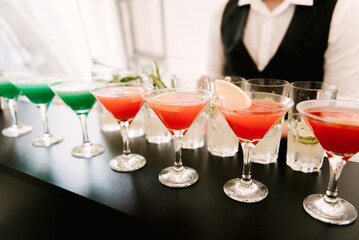Whiskey-cola cocktail, mojito-cocktail, orange cocktail, strawberry cocktail in glass glasses with straws. Bar accessories