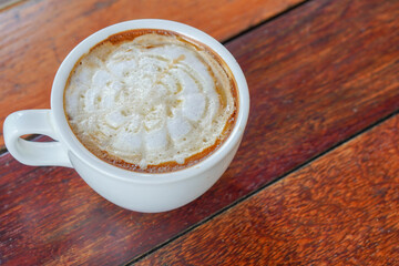 closeup hot coffee in white ceramic cup on a wooden floor background, food, drink, copy space