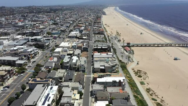 Flying Above Beachfront Buildings And Pier At Hermosa Beach In California, United States On A Sunny Day. aerial drone