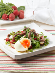 Ensalada de rúcula con anchoas y huevo. Arugula salad with ah choras and egg.