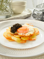 Huevos fritos con patatas y morcilla. Fried eggs with potatoes and black pudding.