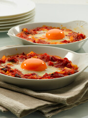 Huevos al plato con salsa de tomate. Eggs on a plate with tomato sauce.