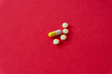 Medications and pills on a red background.