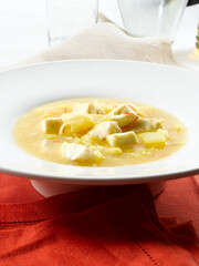 Sopa de lubina y patata sobre plato hondode pocelana blanca. Sea bass and potato soup on a white porcelain bowl