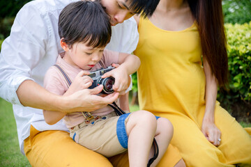 little boy taking photo with mom and dad, happy family.