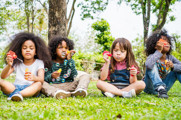 Fototapeta premium happiness children caucasian blow soap bubble in park.