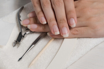 Women's hands on a towel. Manicure. Manicure tools, nail Polish. Home nail care, SPA, beauty. Long natural nails. Beauty salon.	