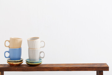 colorful cups on  wooden shelf on  white background