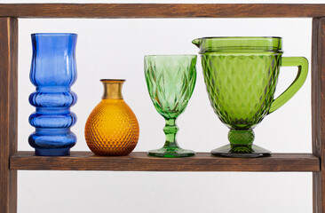 glass vases on wooden shelf on white background