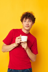cute red-haired guy posing with a white mug and in the hands of a drink Lifestyle unaltered