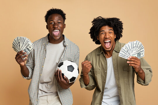 Sport Bets. Portrait Of Excited Black Guys With Football Ball And Money