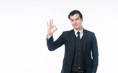 Confident smile handsome businessman wear suit using finger make sign ok for good idea or job while standing over isolated white background. Agreement, winner, business successful concept.