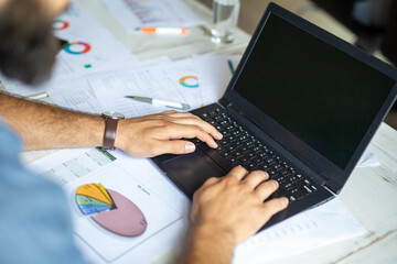 Successful businessman working in the office analyzing business data on notebook