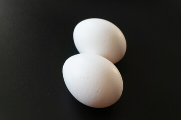 Raw chicken egg on a black background