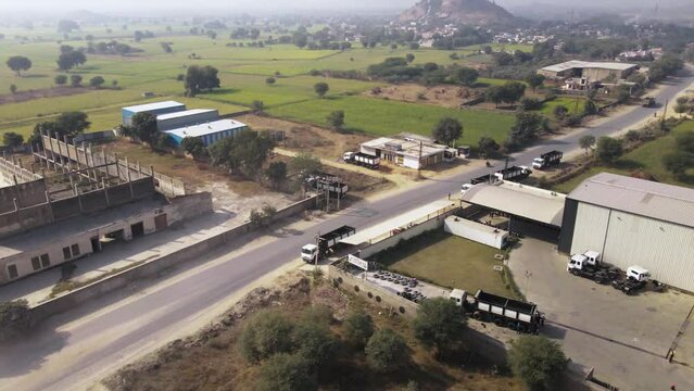Aerial view of indian factory manufacturing warehouse building in Rajasthan green natural landscape.