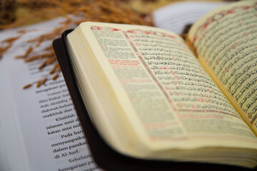 Fototapeta premium small holy quran with indonesian translate extreme close up