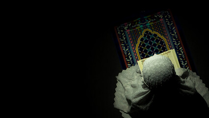 a girl praying in the prayer matt while reading quran