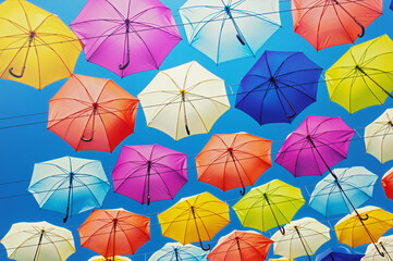 Fototapeta na wymiar Colorful umbrellas on the sky background, toned. 