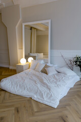 Bedroom in the apartment Mattress nearby Mirror on the wall Minimalistic interior