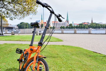 Bicycle in a city park near the Daugava River against the backdrop of the old city of Riga, Latvia. Bicycle in the city, environmentally friendly mode of transport.