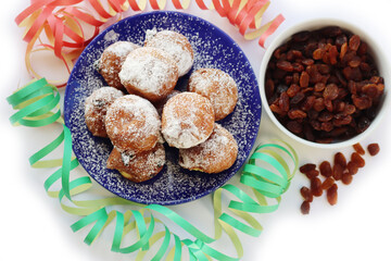Traditional italian Fritters called Frittelle on white with Carnival decorations. Fritters with raisins