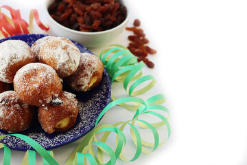 Traditional italian Fritters called Frittelle on white with Carnival decorations. Fritters with raisins